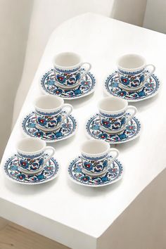 a white table topped with lots of cups and saucers