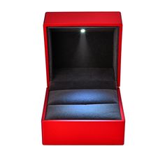 an open red box with a ring on the inside and light coming out from it