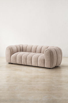 The Alba Sofa, an embodiment of sculptural allure and refined comfort. Inspired by modernist forms, the Alba Sofa exudes an inviting elegance with its rhythmic channel tufting, gracefully enveloping a curvaceous silhouette. Upholstered in luxuriously textured, neutral fabric, it evokes a sense of serene sophistication, harmonising effortlessly with diverse interiors.