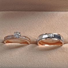 two wedding bands with diamonds on them sitting next to each other in a ring box