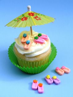 a cupcake with frosting and decorations on top, next to candy candies