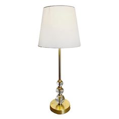 a lamp with a white shade on top of it and a gold base around the lamp