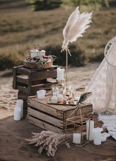 a wooden crate with candles and some feathers on top of it next to a teepee