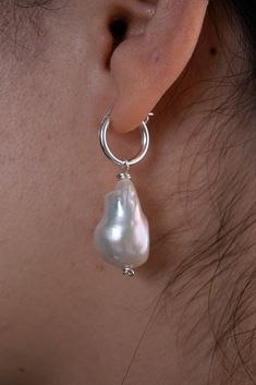 A simple, yet elegant gold-filled or sterling silver hoop earring with a single AAA baroque freshwater pearl charm. Specifications: Size: 2 x .5 inches Materials: 14k Gold, Sterling Silver, Freshwater Pearl 90-97% Clear, High Luster/Nacre All orders come with a handwritten note, a sturdy cardboard drawer box, and a velvet pouch. Note: Each piece is hand-selected and hand-made to order. All of our natural materials vary in size and detailing, so each piece is uniquely your own. Silver Hoop Earring, Drawer Box, Velvet Pouch, Sterling Silver Hoop Earrings, Pearl Charms, Sterling Silver Hoops, Ring Collections, Silver Hoops, Baroque Pearls