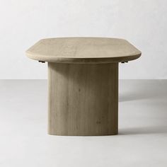 a round wooden table sitting on top of a white floor