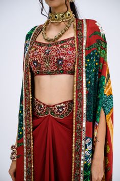 This stunning set features a red Mughal cape paired with an intricately embroidered bralette and a matching skirt. Perfect for festive occasions or special events, this ensemble brings together traditional elegance with a contemporary twist. Festive Sets With Intricate Embroidery And Cape Sleeves, Red Pre-draped Saree With Intricate Embroidery For Party, Traditional Festive Sets With Cape Sleeves, Festive Traditional Sets With Cape Sleeves, Traditional Pre-draped Saree With Cape Sleeves For Festive, Traditional Sets With Cape Sleeves For Diwali, Traditional Diwali Sets With Cape Sleeves, Bohemian Party Sets With Cape Sleeves, Traditional Georgette Lehenga With Cape Sleeves