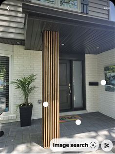 the front entrance of a house with wooden columns and plants on the side walk next to it