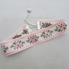 a white and pink ribbon with flowers on it