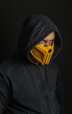 a man wearing a yellow mask and black jacket