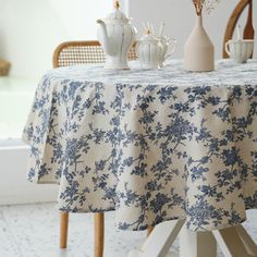 the table is covered with blue and white floral print fabric, along with two vases