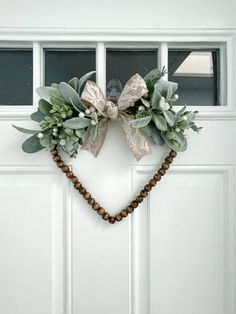 a heart shaped wreath hanging on the front door