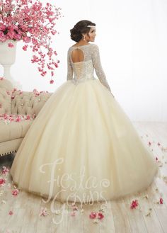 a woman in a wedding dress standing next to a flowery tree with pink flowers