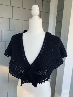 This triangular hand knit Shawl measures 78" long. It is knit using a black yarn with tiny sequins scattered throughout. The edging has a cable lace throughout; it would be a nice accent to a formal outfit also a perfect gift. Gift wrapping available. Black Yarn Knitting Pattern, Black Shawl With Traditional Patterns For Festivals, Black Hand Knitted Knitting Pattern, Black Hand Knitted Pattern, Black Embroidered Shawl For Festivals, Black Knitted Shawl, One Size Black Knitted Shawl, Elegant Black One-size Shawl, Bohemian Black Shawl With Woven Motifs