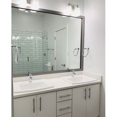 a bathroom with two sinks and a large mirror