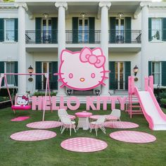 a hello kitty themed party in front of a large white building with pink polka dots on the lawn