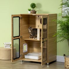 a cat sitting on top of a wooden cabinet