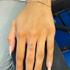 a close up of a person's hand with a diamond ring on her finger