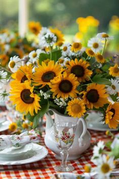 sunflowers and daisies are arranged in white vases on a checkered tablecloth