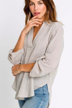 Taupe Roll Tab Sleeve Top - collarless top - tunic top - taupe top  All you need is your favorite shades and the Just In Time Taupe Roll Tab Sleeve Top! Taupe woven blend fabric shapes a V-neckline, and relaxed bodice with rounded hem. Tunic length and three-quarter sleeves with button tabs. Relaxed Fit Split Neck Vacation Blouse, Relaxed Split Neck Blouse For Vacation, Relaxed Fit Split Neck Blouse For Vacation, Beige V-neck Blouse With Relaxed Fit, Neutral V-neck Beach Top, Fall Beach Tops With Split Neck, Relaxed Fit Blouse With 3/4 Roll-up Sleeves, Neutral V-neck Blouse For Fall, Chic Blouse With 3/4 Roll-up Sleeves