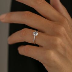 a woman's hand with a diamond ring on it