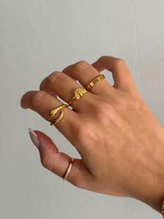 Gold coiled snake ring is adorable and edgy, and a very trendy look for jewelry. Cute serpent snake ring that non-tarnishing - stainless steel and gold - non-tarnishing Socials: Insta: @vasi.jewelry  Site: http://vasijewelry.com Tik Tok: vasi.jewelry Care - protect your jewelry from things that could scratch the surface - keep away from harsh chemicals - store jewelry away from the sun and in a microfiber pouch - clean your pieces with warm water and detergent-free soap and thoroughly dry - poli Ring Stack Mixed Metal, Gold Minimalist Snake Ring For Promise, Gold Minimalist Snake Ring As Promise Ring, Gold Snake Ring As Gift, Gold Plated Snake Ring Gift, Gold Minimalist Snake Ring For Gift, Adjustable Gold Snake Ring, Gold Minimalist Snake Ring, Minimalist Snake Ring As A Gift