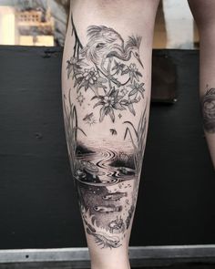 a woman's leg with tattoos on it and flowers in the water below her