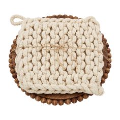 a white crocheted pillow on top of a wooden stand with rope around it