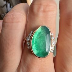 Holy Moly this is a RING. A stunning rosecut Zambian Emerald is set in buttery 14k yellow gold. Accented with over 1/4th of a ct of Brilliant white diamonds and Emily's seagrass band this is truly a ring that will be forgotten. Approx stone size: 18mm x 11mm Approx ct weight: 4.7cts Approx diamond ct: .26cts Mohs hardness: 8 This one of a kind piece is handmade with love in Emily's Hudson Valley studio. It is currently in stock and ready to size and ship. If you have questions about sizing, ship Oval Emerald Ring With Single Cut Diamonds, Oval Emerald Ring With Rose Cut Diamonds, Heirloom Oval Emerald Ring With Single Cut Diamonds, Exquisite Oval Emerald Ring With Rose Cut Diamonds, Oval Rose Cut Diamond Rings For May Birthstone, Heirloom Oval Emerald Ring With Rose Cut Diamonds, May Birthstone Rose Cut Diamond Ring, 14k Gold Jewelry With Green Rose Cut Diamonds, 14k Gold Green Jewelry With Rose Cut Diamonds