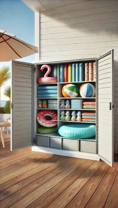 an open cabinet filled with lots of different items on top of a wooden floor next to a table and umbrella