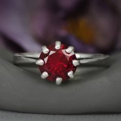 This dramatic Sterling Silver 8-prong Round Ruby Ring features a sparkling 8 mm round gemstone. The detailing on the setting mimics a basic lattice design that includes the the delicate prongs. When antiqued, this simple design emphasizes the deep color of the stone. The ring tapers gracefully from the stone to a 2.3 mm band, and the stone stands a captivating 7 mm high to gather plenty of attention! Although this piece is shown as created with a ruby, we are happy to create this ring with your Ruby Engagement Ring Vintage, Ruby Wedding Ring, Silver Ruby Ring, Ruby Wedding Rings, July Birthstone Ring, Ruby Wedding, Buy Jewellery Online, Engagement Ring Vintage, Ring Mountings