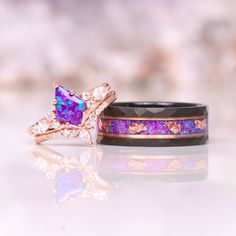 Introducing the Skye Purple Fire Opal Couples Ring Set, a stunning representation of everlasting love and commitment. This exquisite matching wedding band set combines unique design elements with high-quality materials to create a truly special symbol of your union. ►The men's ring, crafted with precision and artistry, features a hammered and brushed black tungsten carbide band. The distinctive texture adds a touch of rugged elegance, complemented by a captivating crushed opal and rose gold foil inlay. This combination of elements creates a mesmerizing play of colors and textures, symbolizing the depth and strength of your bond. ►On the other hand, the women's ring exudes feminine grace with its 14k rose gold vermeil finish. The base metal, meticulously crafted from 925 sterling silver, pr Luxury Purple Jewelry For Wedding, Heirloom Purple Wedding Rings, Heirloom Purple Ring For Wedding, Heirloom Purple Rings For Weddings, Luxury Vvs Clarity Amethyst Wedding Ring, Purple Diamond Cut Jewelry For Wedding, Heart Cut Amethyst Ring With Accent Stones For Wedding, Wedding Amethyst Heart Cut Ring With Accent Stones, Elegant Purple Opal Anniversary Ring