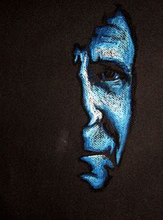 a man's face painted in blue on a black background