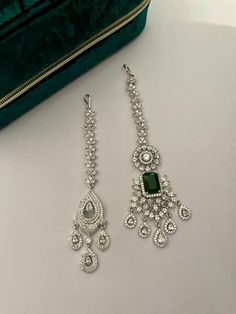 Add a touch of sparkle to your look in our enchanting diamond bridal maang tika! Beautiful head jewelry showcasing CZ diamond and green stone intricately crafted for you. Colour Options: Green Silver Details of Green Tika: Length-4.75 Inches Width-1.25 Inches Weight-17 gms Details of Silver Tika: Length-4.25 Inches Width-1 Inch Weight-11 gms All products are manufactured using traditional skills from our rich heritage of crafts.  The process of these crafts is essentially manual. Hence, any irre Head Jewelry Headpieces, Maang Tika, Headpiece Jewelry, Head Jewelry, Jewelry Showcases, Hair Jewelry Wedding, Headpiece Wedding, Wedding Jewellery, Green Diamond