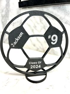 a metal soccer ball holder with the number nine on it's front and back sides