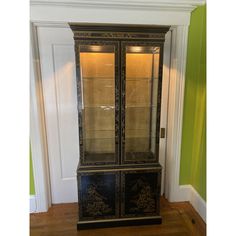 an antique china cabinet with glass doors and gold trim