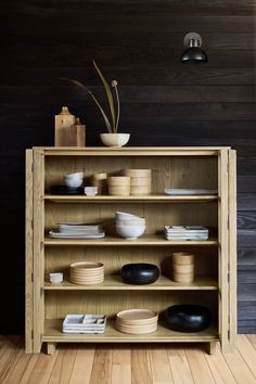 a wooden shelf filled with plates and bowls