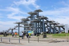 several people are standing in front of a large structure