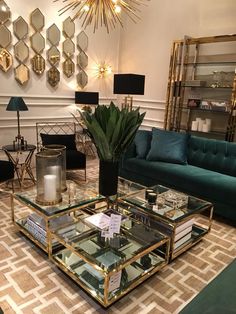 a living room filled with lots of furniture and mirrors on the wall above it's coffee table