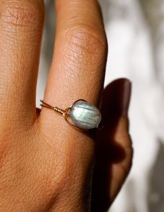 A simple, magical, elegant 14k gold-filled wire-wrapped ring featuring an oval shaped grade A labradorite bead imported from Japan. Discover yourself with the power of labradorite and its connection to mystical lore and ancient legends - it is said that this gemstone is a crystal that can be traced back to the native tribes in icy Canada, created from frozen fire which is a result of the northern lights. Its iridescent blues, greens, yellows reminds us of the magic in the spirit world while also Minimalist Wire Wrapped Open Ring Jewelry, Elegant Everyday Wire Wrapped Rings, Oval Hand Wrapped Rings As A Gift, Oval Hand Wrapped Rings For Gift, Delicate Wire Wrapped Ring Jewelry, Elegant Adjustable Labradorite Ring, Dainty 14k Gold Filled Wire Wrapped Rings, Handmade Minimalist Oval Crystal Ring, Wire Wrapped 14k Gold Filled Rings As Gift