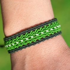 a person wearing a green and white bracelet