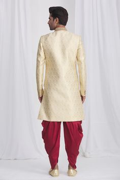 Gold sherwani in jacquard silk brocade base fabric featuring floral motifs and embellished button details. Paired with contrast dhoti pant.
Component: 2
Neckline: Mandarin
Sleeve Length: Full
Fabric: Sherwani: Jacquard Silk Brocade; Dhoti: Dupion Art Silk; Lining: Faux Satin
Color: Gold
Front overlap panel
Embellished button details
Elasticated and drawstring waistband
Note: The pocket square worn by the model is for styling purpose only - Aza Fashions Traditional Jacquard Sets For Formal Occasions, Gold Brocade Kurta For Reception, Ceremonial Sherwani With Zari Weaving For Diwali, Ceremonial Gold Sherwani With Self Design, Wedding Bandhgala With Zari Weaving And Long Sleeves, Wedding Long Sleeve Bandhgala With Zari Weaving, Ceremonial Sherwani With Zari Weaving For Transitional Season, Traditional Sherwani With Zari Weaving, Ceremonial Fitted Sherwani With Zari Weaving