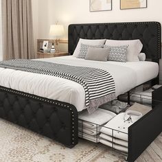 a black and white bed in a bedroom with two nightstands on either side of the bed