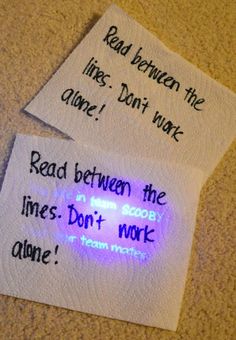 two pieces of paper with words written on them next to a cell phone and light bulb