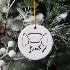 a white ornament hanging from a christmas tree with the word bake on it