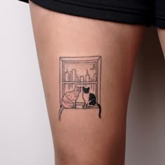 two cats sitting in a window sill tattoo on the side of a woman's thigh