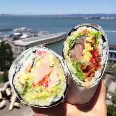 two sushi rolls sitting on top of each other in front of a body of water