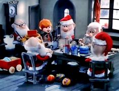 the elves are sitting at the table together for christmas dinner with santa clause hats on