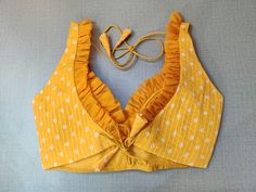 The yellow saree blouse has strappy sleeves and a V-neck with ruffles, hook-and-eye closure on the back, and tie-up detail on the back, for more grace there are beautiful white dots. This readymade saree blouse is a must-have piece. Wear it with a contrasting saree or even with a contrasting lehenga skirt to complete the look. Buy this designer blouse in the USA from Pure Elegance. Disclaimer: The actual product may vary slightly from the image. These are custom orders, hence expect slight variation in color, and placement of the motif, or buta. ESTIMATED DELIVERYBecause this is a custom order, it would take about 4 weeks from the date of purchase. RETURN POLICY: This product is a custom order and cannot be returned or exchanged. Contrasting Lehenga, Yellow Saree Blouse, Banarasi Sari, Designer Sari, Saree Style, Readymade Saree, Yellow Saree, Lehenga Skirt, Fashion Journals