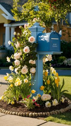 a blue mailbox surrounded by flowers and greenery