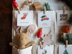 a stuffed animal sitting in a bag next to christmas decorations and cards on a wall